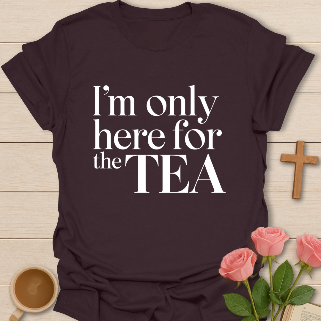 Brown t-shirt with 'I'm only here for the TEA' text on a wooden surface with a cup of tea and roses.