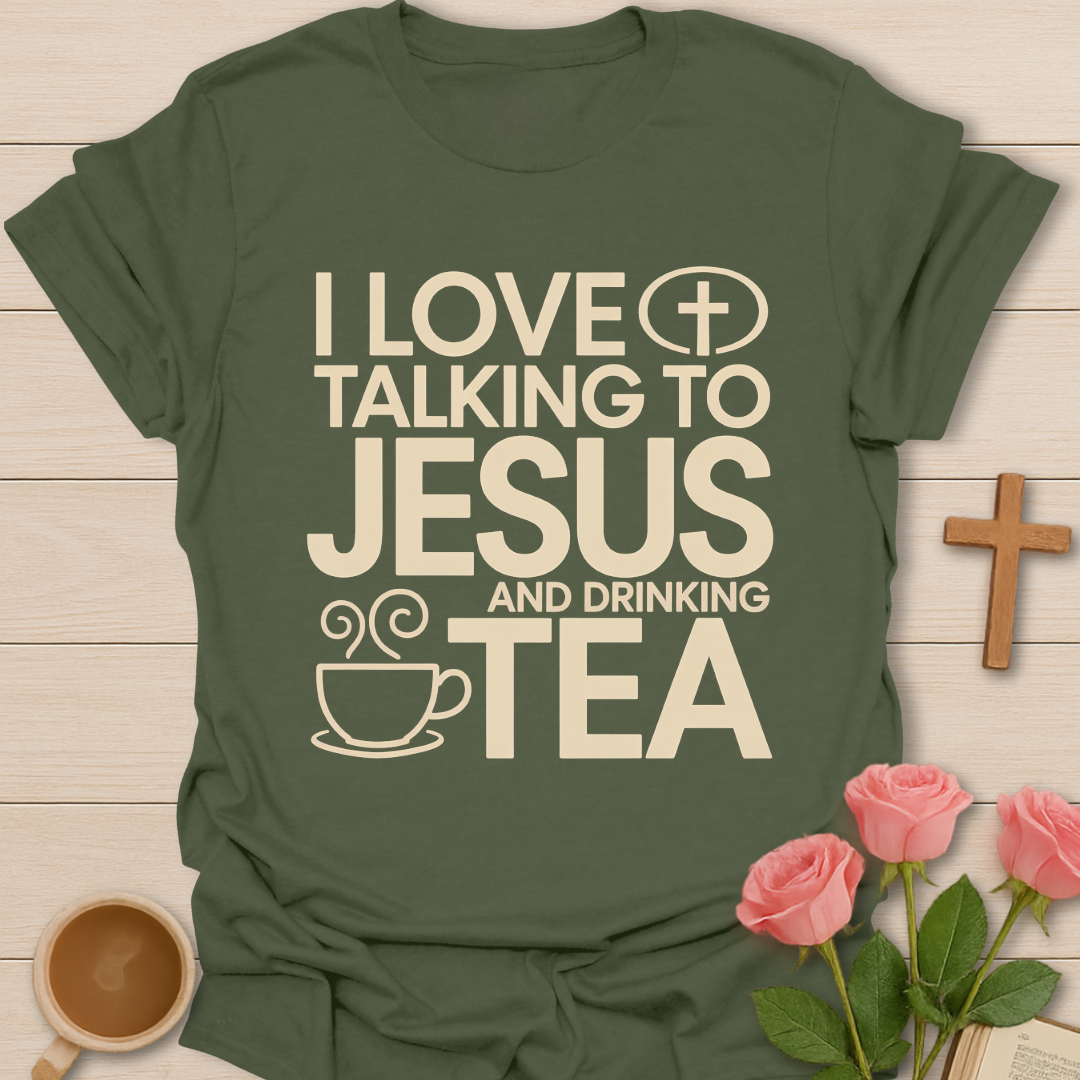 Green t-shirt with text 'I love talking to Jesus and drinking tea' on a wooden surface with a cup of coffee and roses.