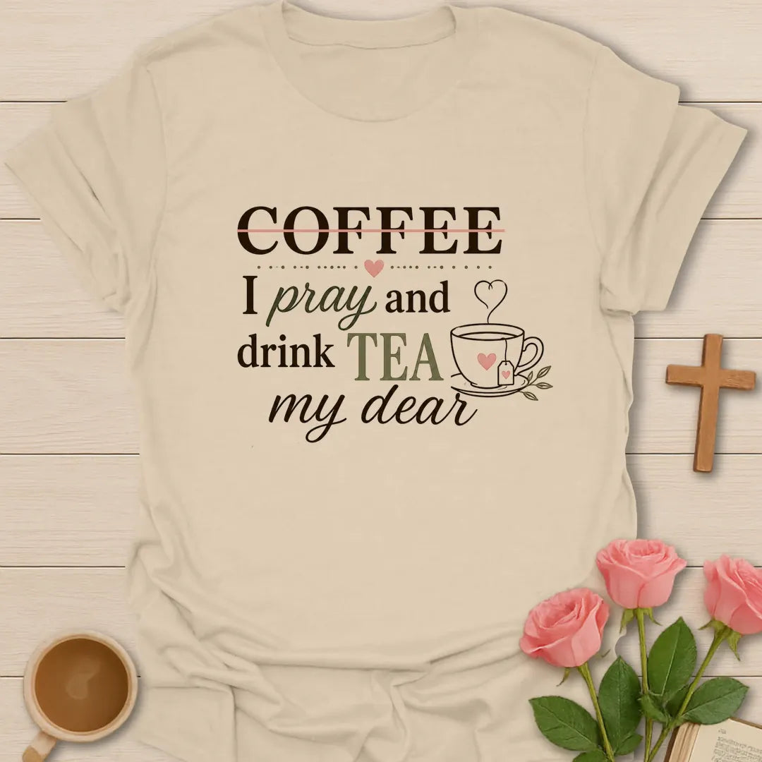 Pray and Drink Tea shirt with teacup, praying hands, and cream vintage lettering. - Sand