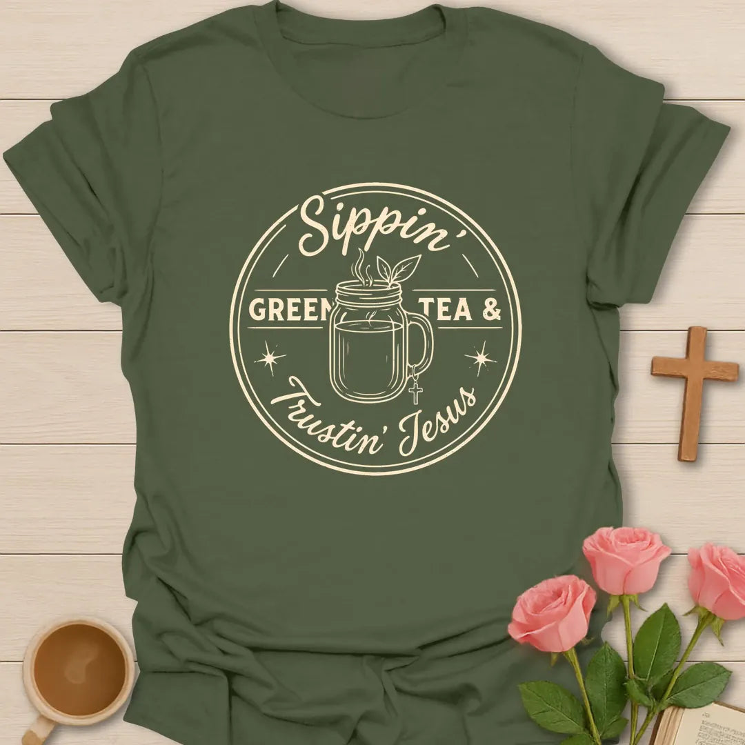 Sippin Green Tea and Trustin Jesus shirt with green tea mason jar, cross charm, leaves, circular badge, and cream lettering. - Military Green