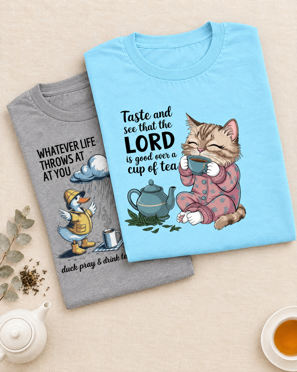 Cheerful woman in a humorous Keepin' It Real T-shirt holding a mug on a cozy sofa with blanket and candle, with Funny Faith + Tea collection text above.