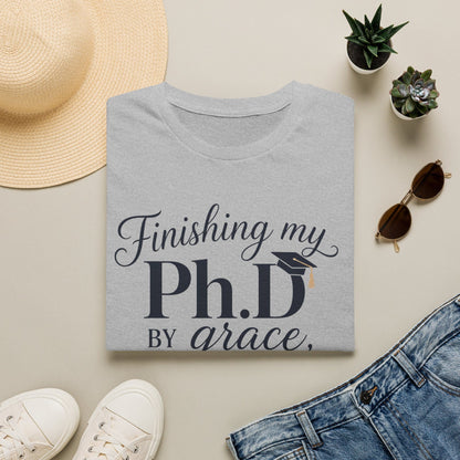PhD By Grace shirt with large navy PhD lettering, graduation cap, script grace text, sleepless nights phrase, and teacup illustration.