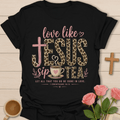 Love Like Jesus Sip Tea shirt with leopard JESUS lettering, teacup, cross, heart, and 1 Corinthians 16:14 text. - Black