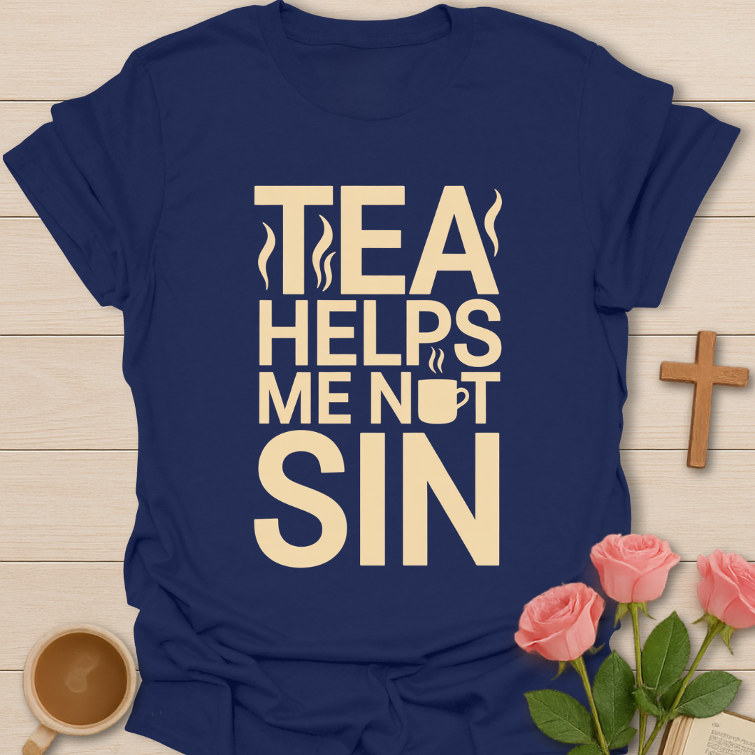 Navy blue t-shirt with 'Tea Helps Me Not Sin' text on a wooden surface with a cup of tea and roses.