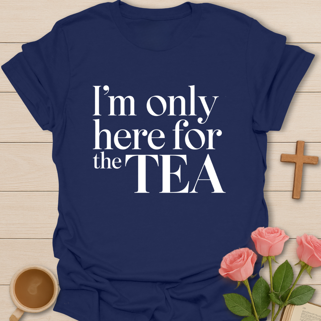 Navy blue t-shirt with 'I'm only here for the TEA' text on a wooden surface with flowers and a cup.