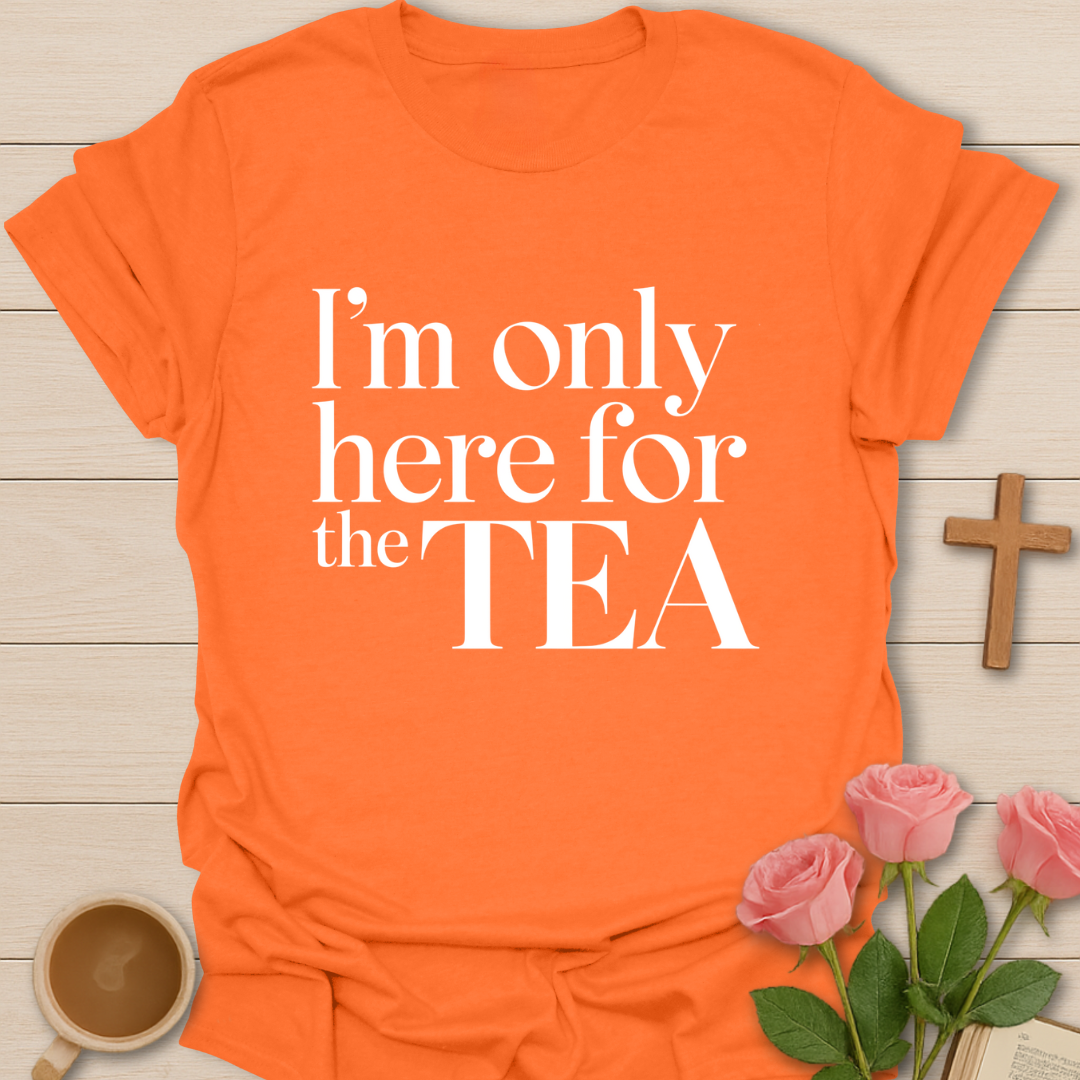 Orange t-shirt with 'I'm only here for the TEA' text on a wooden surface with a cup of coffee and roses.