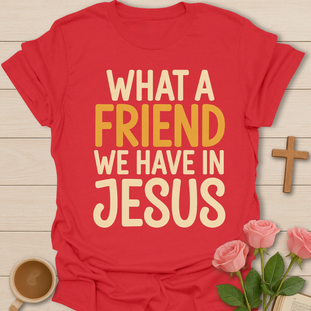 Red t-shirt with 'What a friend we have in Jesus' text on a wooden surface with flowers and a cross.