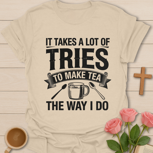 Beige t-shirt with humorous tea-making quote on a wooden surface with a cup of tea and roses.