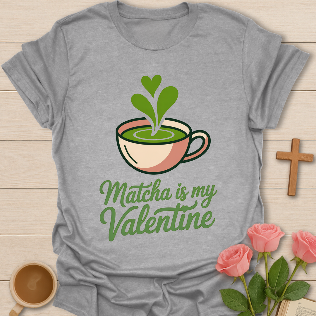 Gray t-shirt with matcha graphic and text on a wooden surface with flowers and a cup.