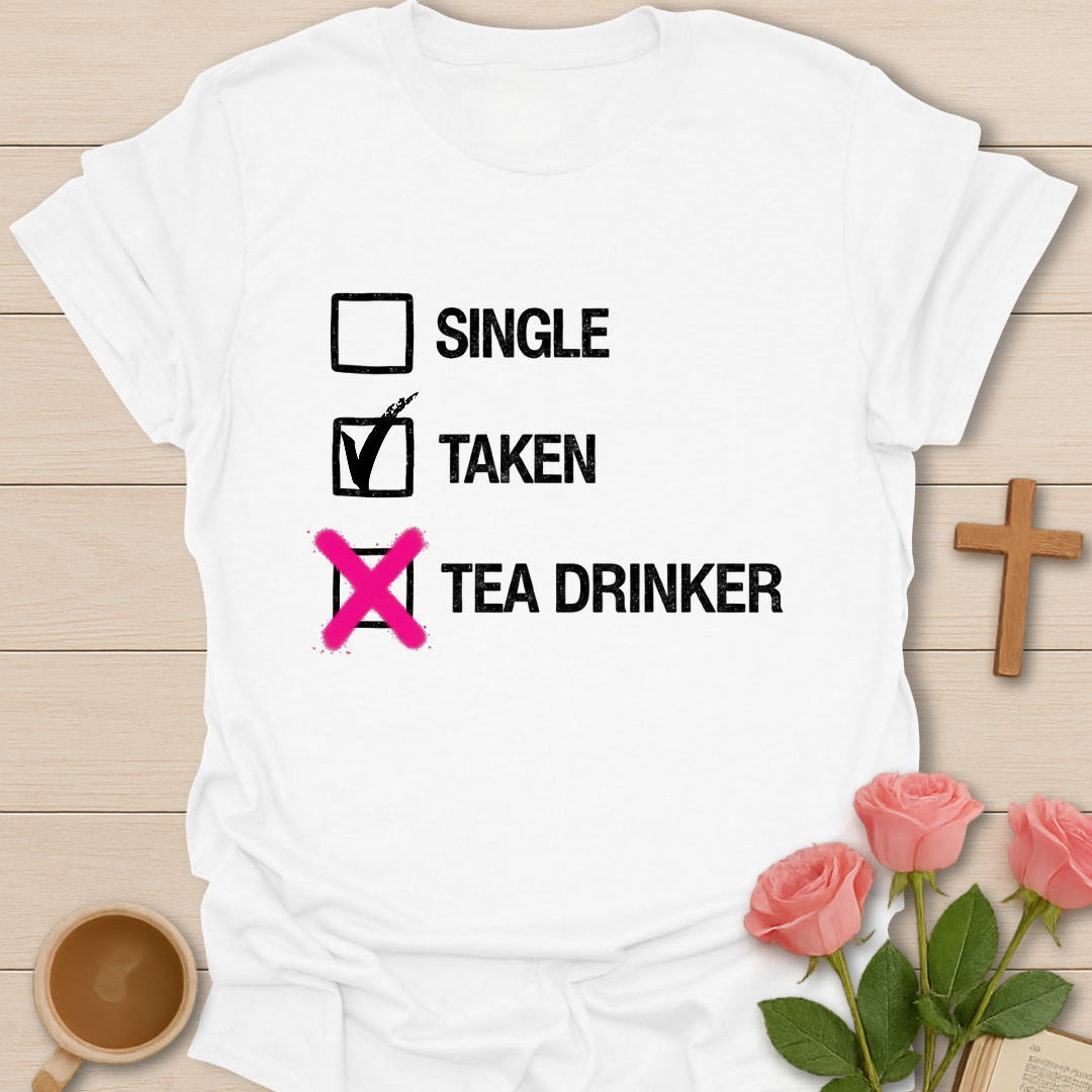 White t-shirt with humorous text design on a wooden surface with flowers and a cross.