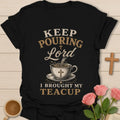 Keep Pouring Lord, I Brought My Teacup t-shirt with vintage lettering and tea pouring into a cross-marked teacup. - Black