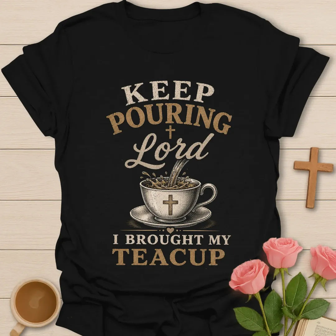 Keep Pouring Lord, I Brought My Teacup t-shirt with vintage lettering and tea pouring into a cross-marked teacup. - Black