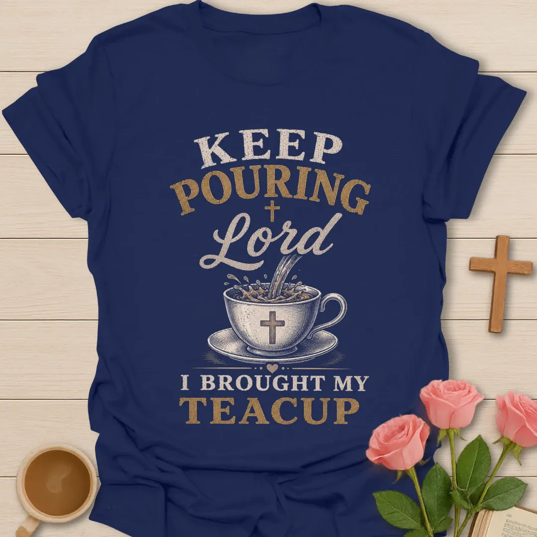 Keep Pouring Lord, I Brought My Teacup t-shirt with vintage lettering and tea pouring into a cross-marked teacup. - Navy