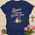 Sippin Chai and Trustin Jesus shirt with mason jar chai, straw, cross tea tag, steam, flowers, and cream vintage lettering. - Navy