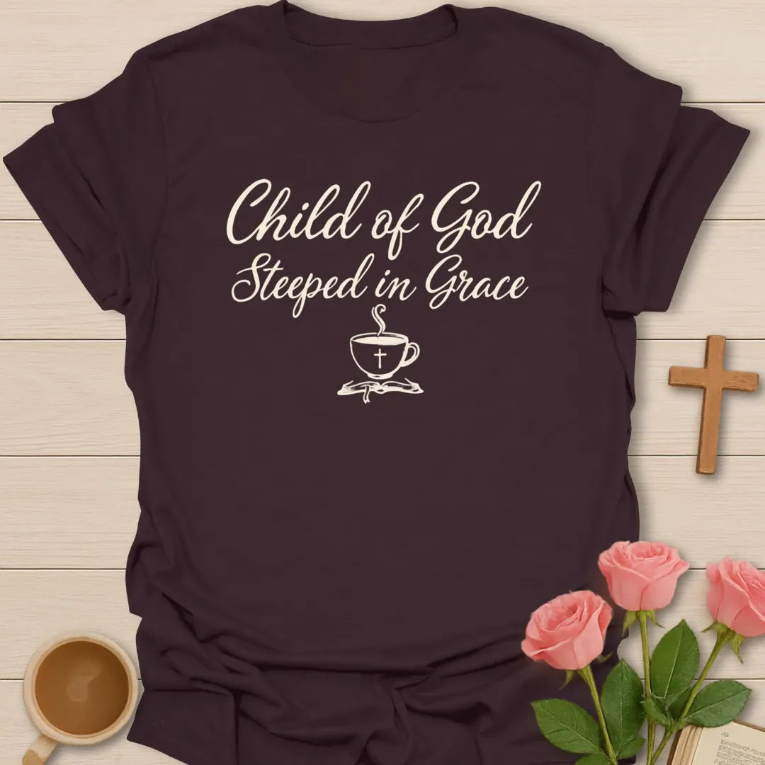 Child of God Steeped in Grace shirt with cream script lettering, teacup with cross, and minimalist faith design. - Dark Chocolate