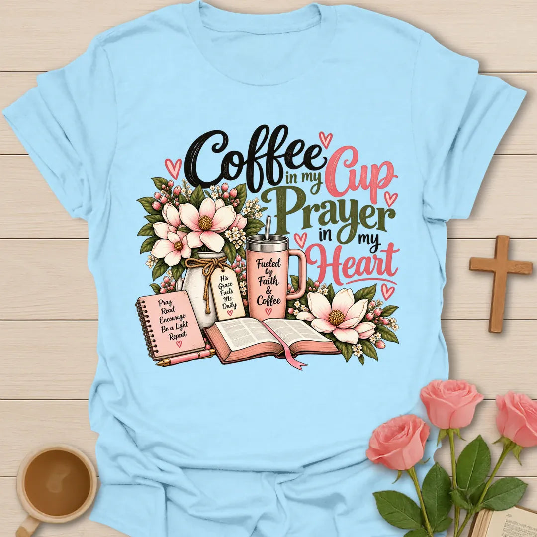Coffee In My Cup, Prayer In My Heart Christian t-shirt with pink flowers, an open Bible, a prayer journal, and a coffee tumbler - Light Blue