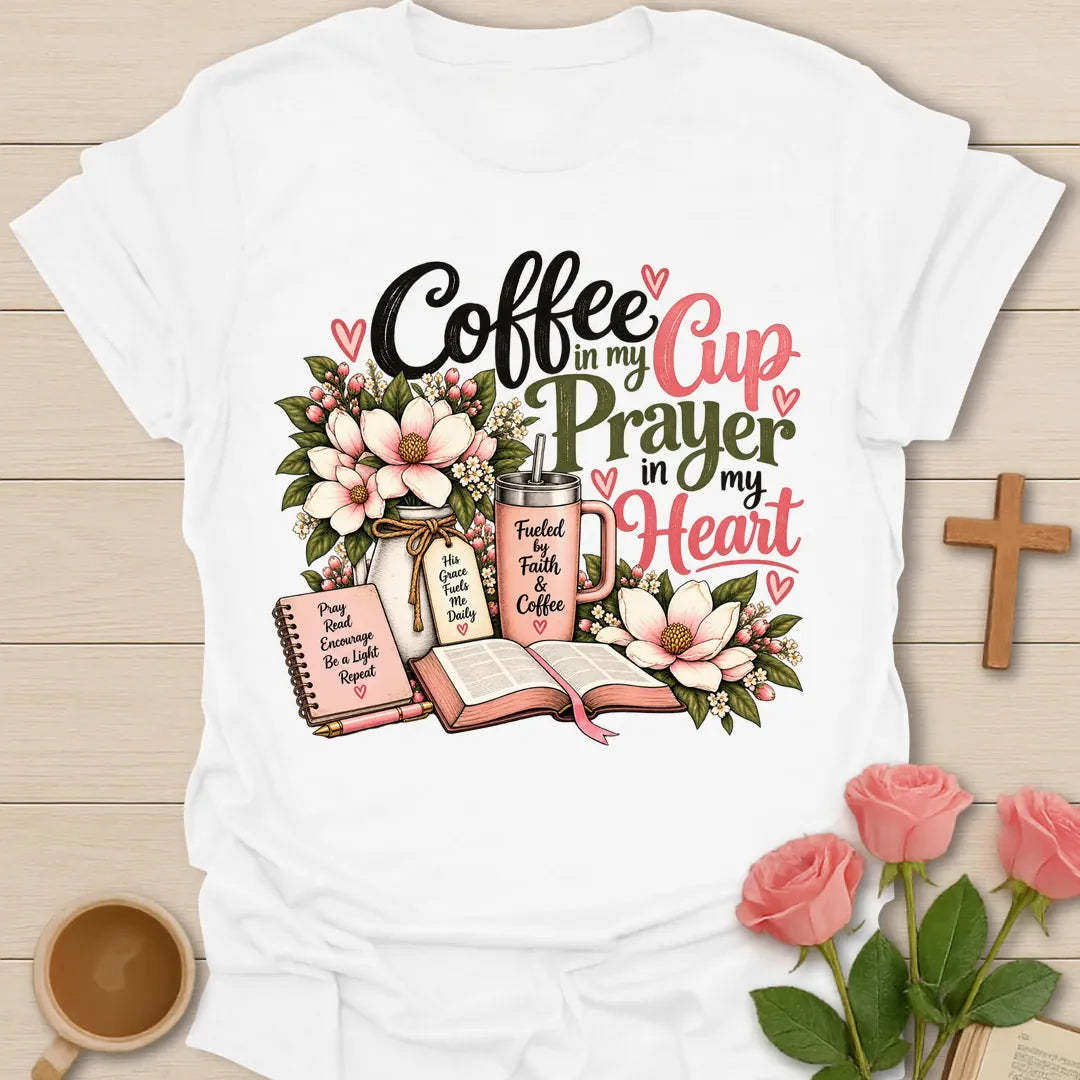 Coffee In My Cup, Prayer In My Heart Christian t-shirt with pink flowers, an open Bible, a prayer journal, and a coffee tumbler - White