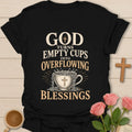 God Turns Empty Cups Into Overflowing Blessings t-shirt with vintage lettering and an overflowing teacup marked with a cross. - Black