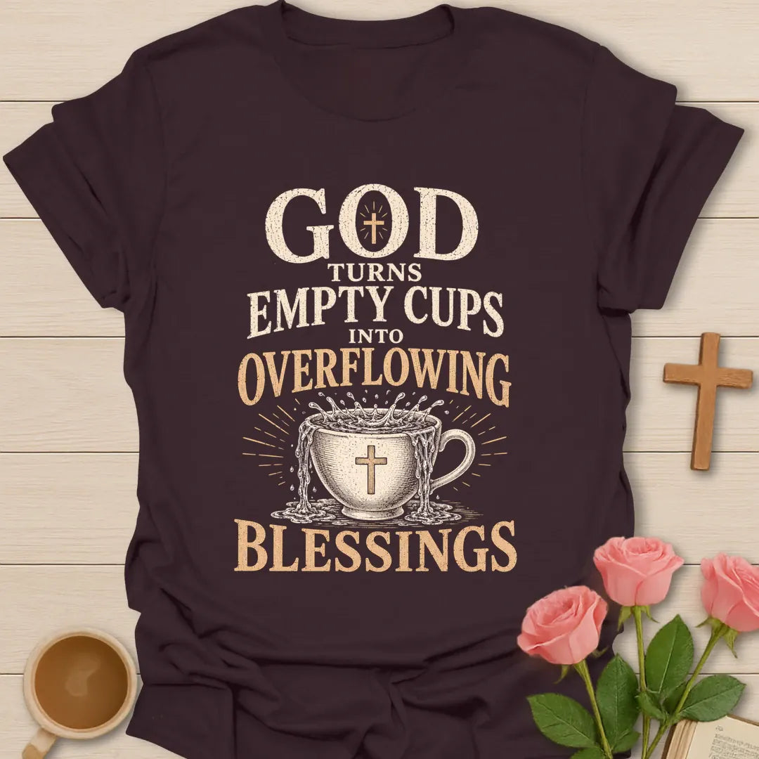 God Turns Empty Cups Into Overflowing Blessings t-shirt with vintage lettering and an overflowing teacup marked with a cross. - Dark Chocolate
