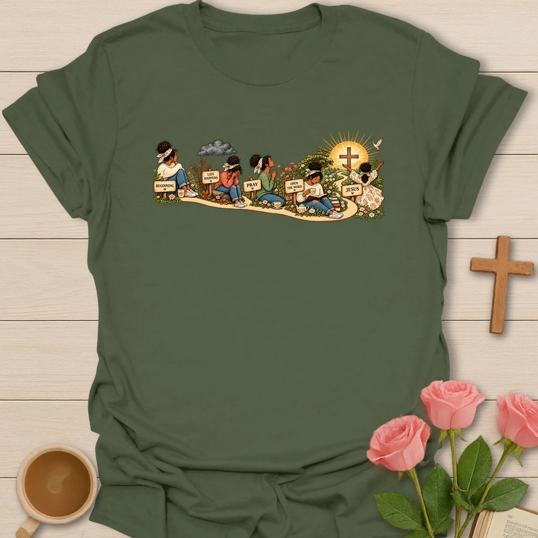 Faith Story t-shirt showing a woman's journey along a path with signs reading Beginning, Life Happens, Pray, Open The Word and Jesus, ending at a cross in a sunrise - Military Green