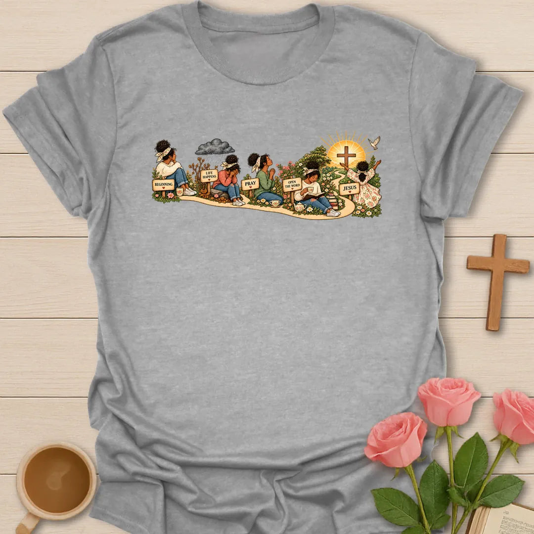 Faith Story t-shirt showing a woman's journey along a path with signs reading Beginning, Life Happens, Pray, Open The Word and Jesus, ending at a cross in a sunrise - Sport Grey