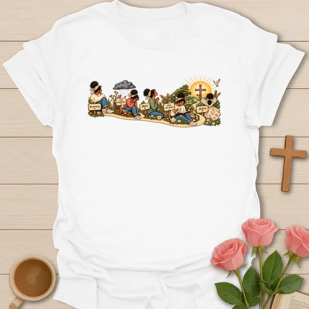 Faith Story t-shirt showing a woman's journey along a path with signs reading Beginning, Life Happens, Pray, Open The Word and Jesus, ending at a cross in a sunrise - White