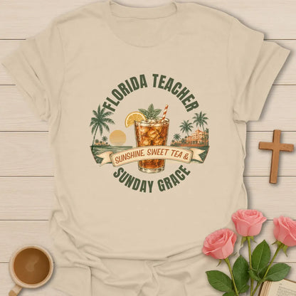 Florida Teacher shirt with arched green text, iced sweet tea glass, orange slice, palms, sunset, ribbon banner, and Sunday Grace wording. - Sand