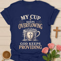My Cup Keeps Overflowing, God Keeps Providing t-shirt with vintage lettering and an overflowing teacup marked with a cross. - Navy