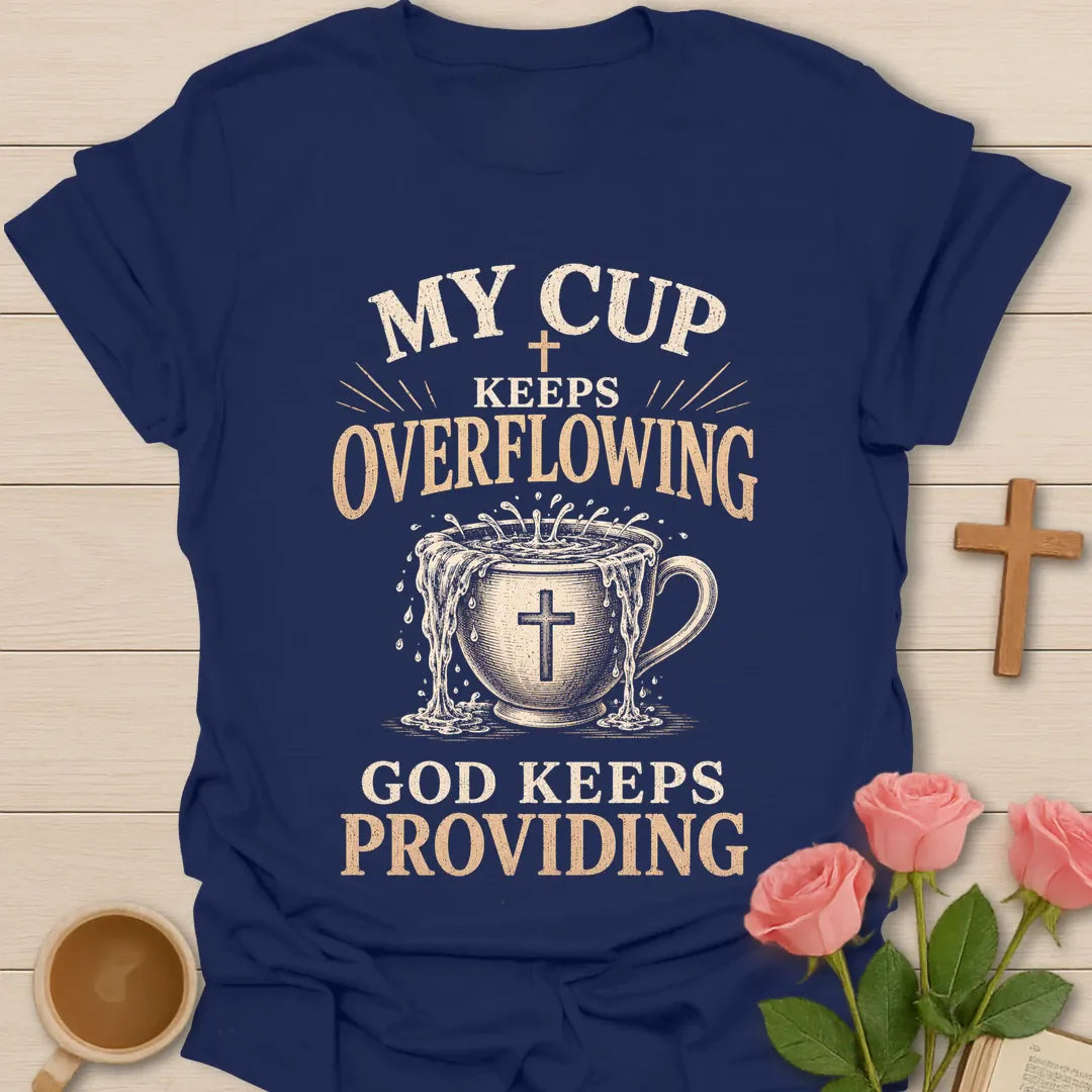 My Cup Keeps Overflowing, God Keeps Providing t-shirt with vintage lettering and an overflowing teacup marked with a cross. - Navy
