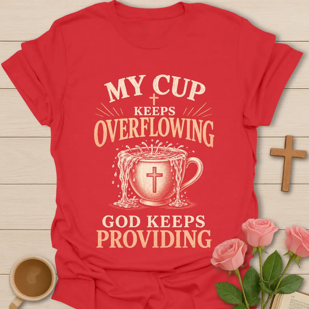 My Cup Keeps Overflowing, God Keeps Providing t-shirt with vintage lettering and an overflowing teacup marked with a cross. - Red