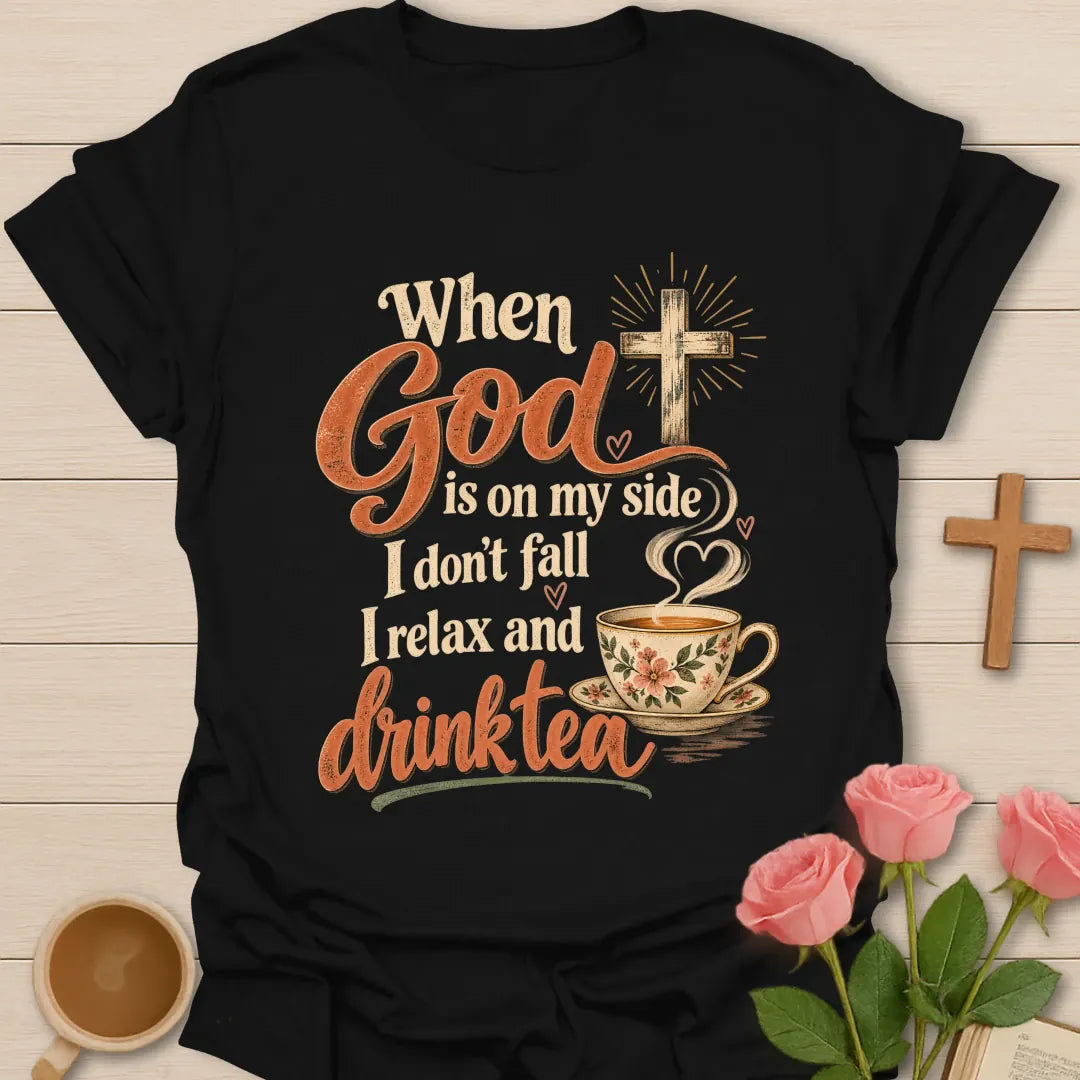When God Is On My Side I Don't Fall, I Relax And Drink Tea t-shirt with a glowing cross and floral teacup in script lettering - Black