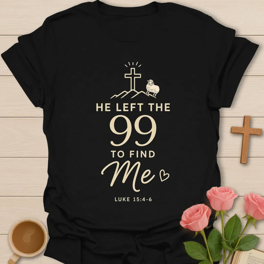 He Left The 99 To Find Me shirt with cross, mountain line art, small sheep, heart, and Luke 15:4-6 text. - Black