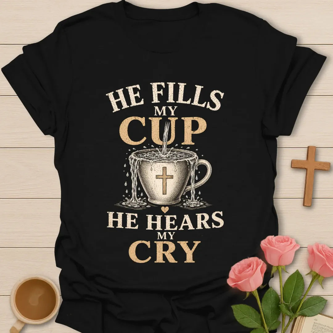 He Fills My Cup, He Hears My Cry t-shirt with vintage lettering and tea pouring into an overflowing cross-marked teacup. - Black