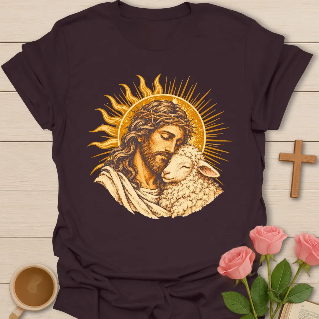 Jesus Embrace t-shirt with a vintage golden illustration of Jesus wearing a crown of thorns holding a lamb close against a radiant sun - Dark Chocolate