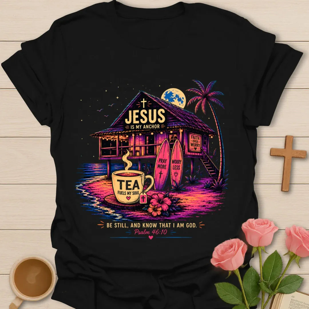 Jesus Is My Anchor tea shirt with beach hut, surfboards, palm tree, moon, teacup, and Psalm 46:10 text. - Black