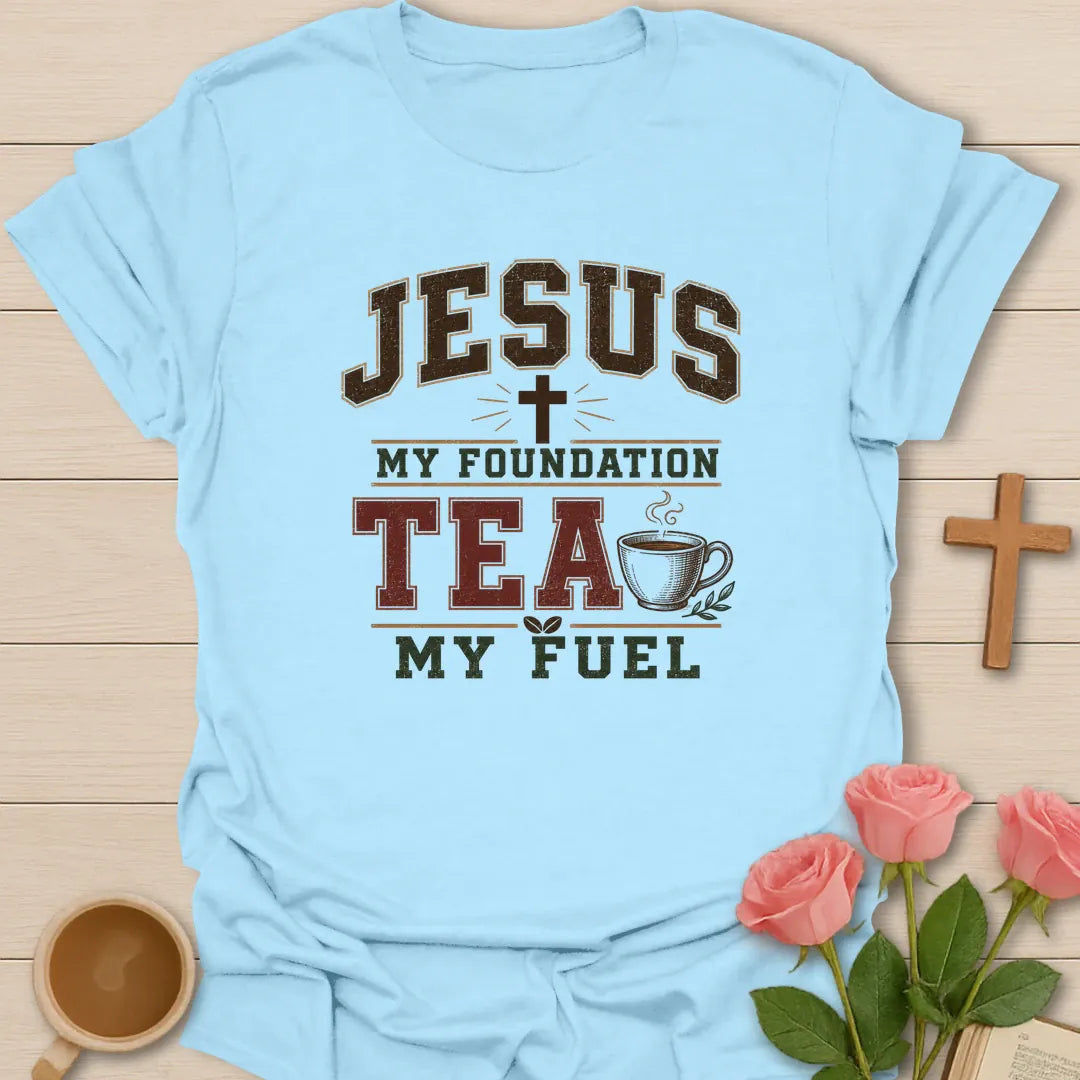 Jesus My Foundation Tea My Fuel shirt with distressed varsity letters, cross, steaming teacup, and earth tone colors. - Light Blue
