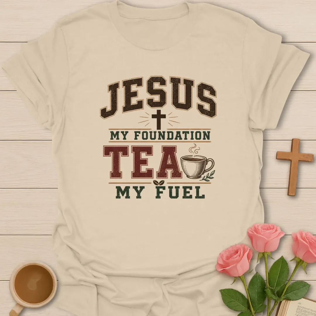 Jesus My Foundation Tea My Fuel shirt with distressed varsity letters, cross, steaming teacup, and earth tone colors. - Sand