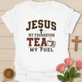 Jesus My Foundation Tea My Fuel shirt with distressed varsity letters, cross, steaming teacup, and earth tone colors. - White