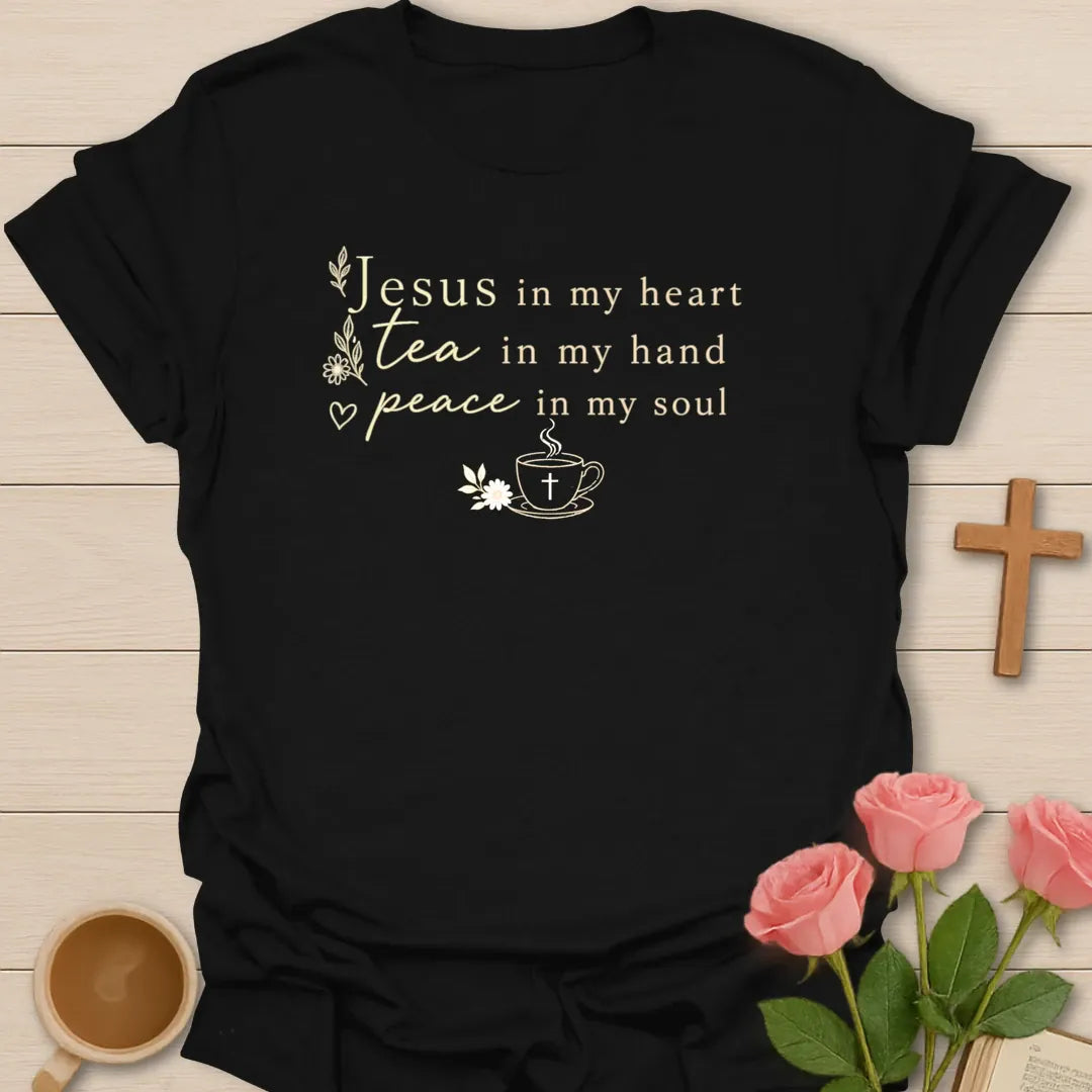 Jesus Tea and Peace shirt with cream serif and script lettering, small teacup with cross, steam, daisies, leaves, and heart accent. - Black