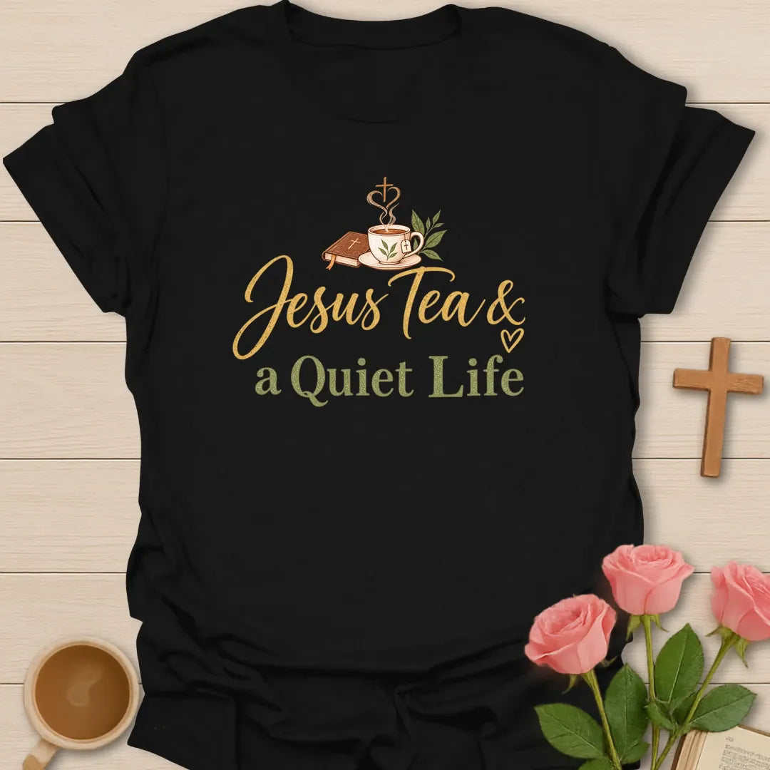 Jesus Tea and a Quiet Life t-shirt with gold and sage script, a closed Bible and a teacup with cross-shaped steam. - Black