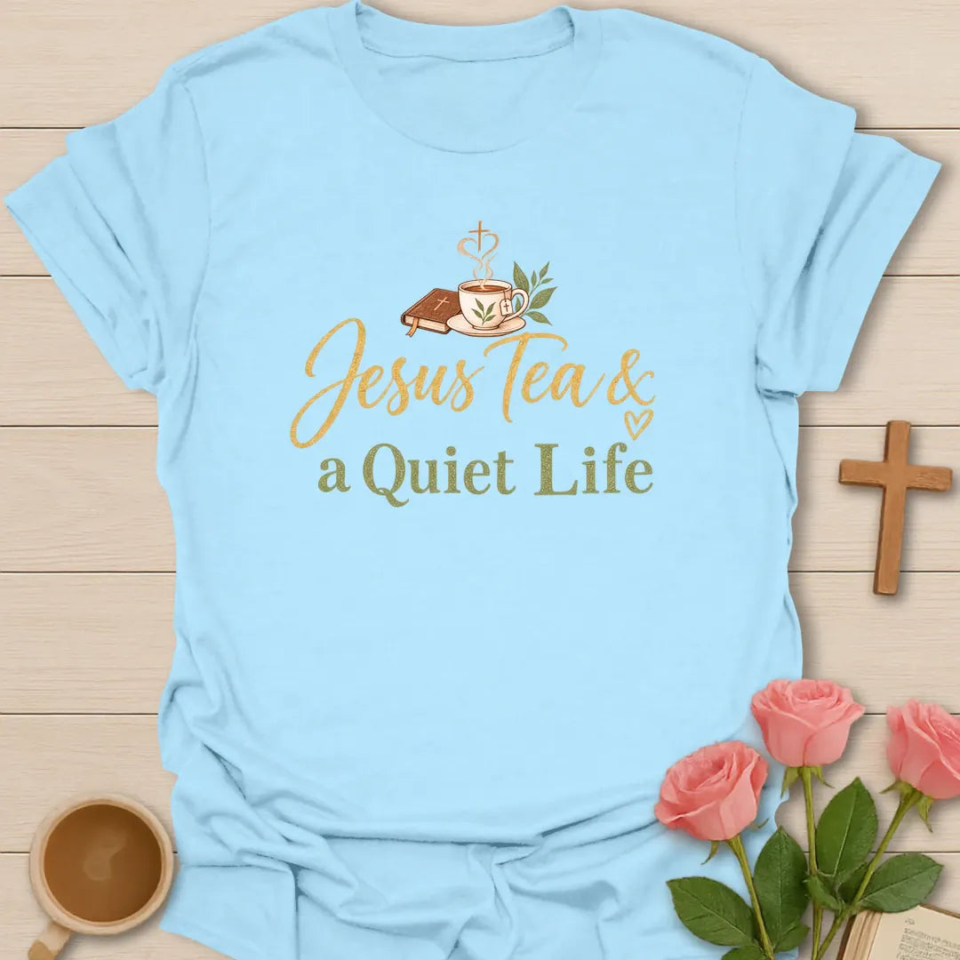 Jesus Tea and a Quiet Life t-shirt with gold and sage script, a closed Bible and a teacup with cross-shaped steam. - Light Blue