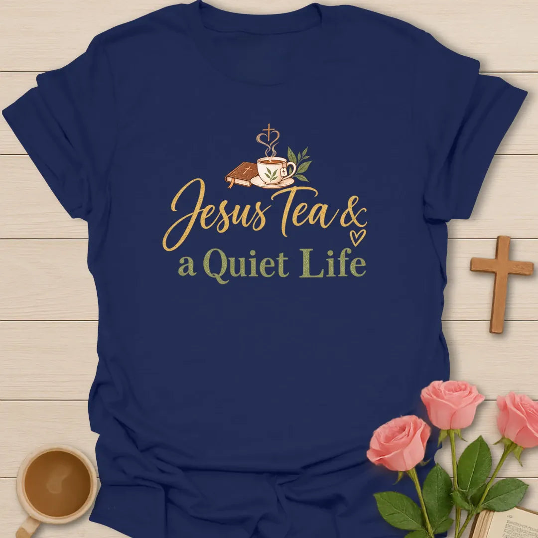 Jesus Tea and a Quiet Life t-shirt with gold and sage script, a closed Bible and a teacup with cross-shaped steam. - Navy