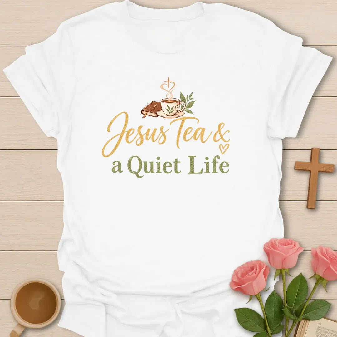 Jesus Tea and a Quiet Life t-shirt with gold and sage script, a closed Bible and a teacup with cross-shaped steam. - White