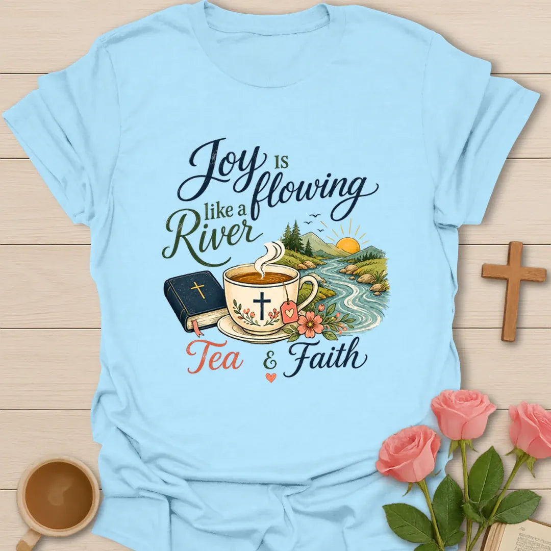Joy Is Flowing Like A River shirt with teacup, Bible, river, mountains, sunrise, flowers, and tea faith text. - Light Blue