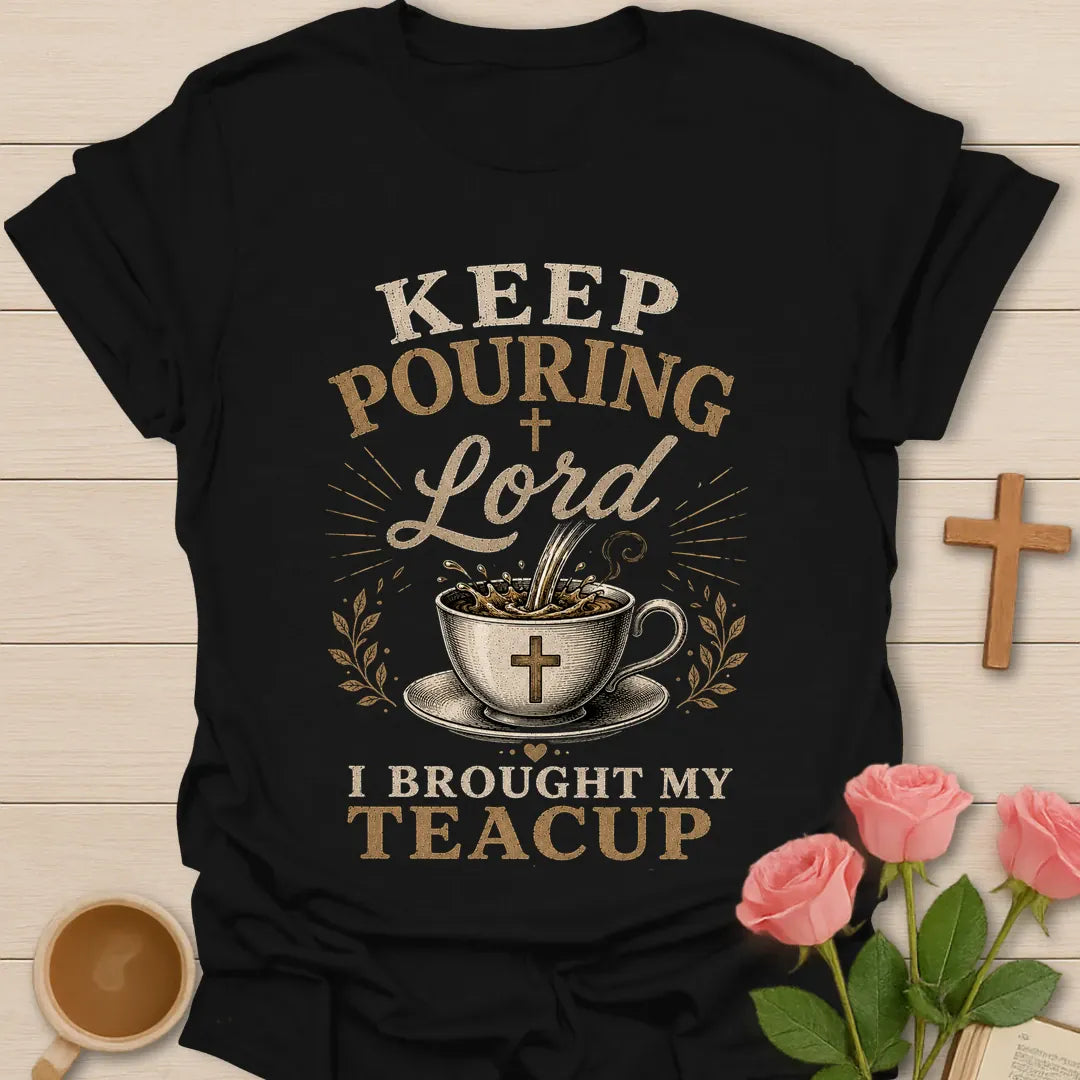 Keep Pouring Lord, I Brought My Teacup t-shirt with vintage lettering and tea pouring into a cross-marked teacup. - Black