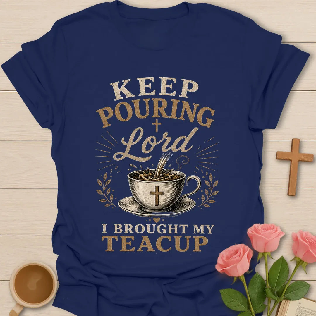 Keep Pouring Lord, I Brought My Teacup t-shirt with vintage lettering and tea pouring into a cross-marked teacup. - Navy