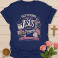 Learning With Jesus back to school shirt with books, backpack, cross, coffee cup, apple, and Philippians 4:13 text. - Navy