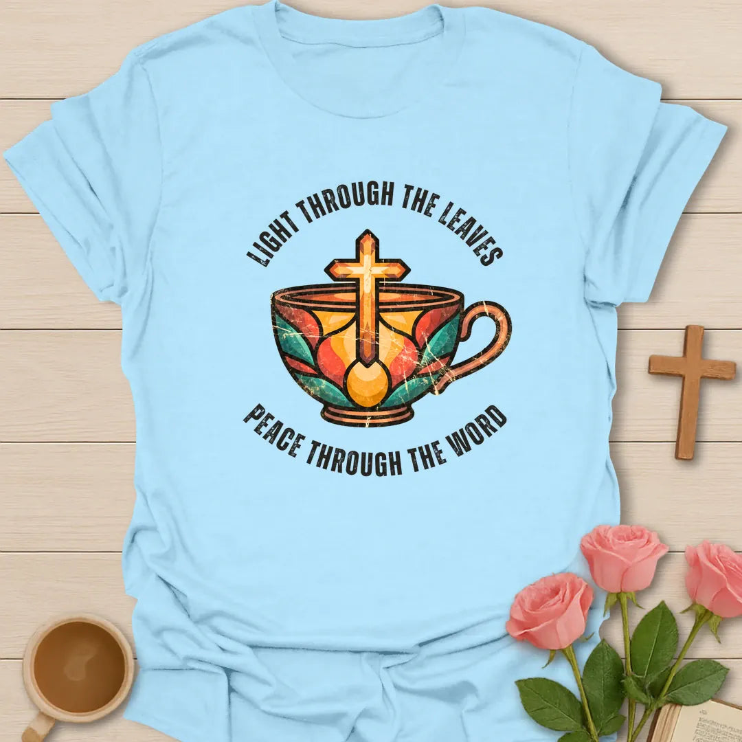 Light Through The Leaves, Peace Through The Word t-shirt with a stained-glass style teacup and golden cross - Light Blue