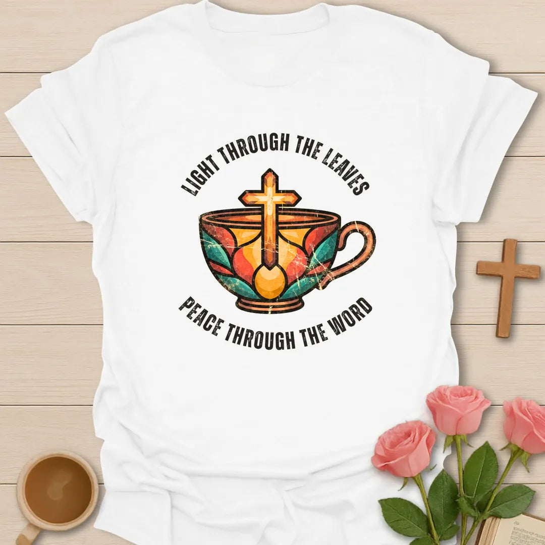 Light Through The Leaves, Peace Through The Word t-shirt with a stained-glass style teacup and golden cross - White
