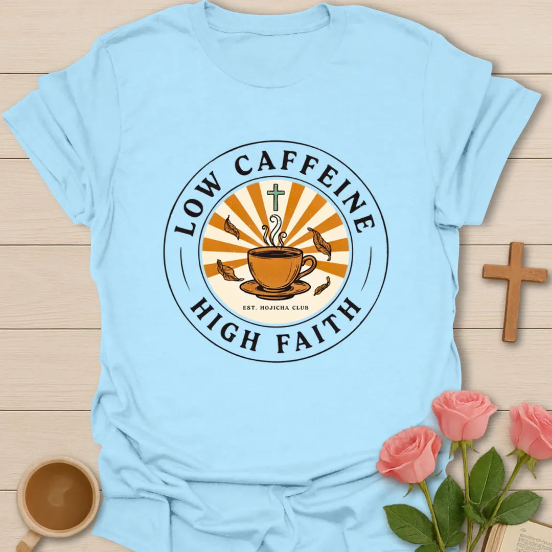 Low Caffeine High Faith shirt with Hojicha tea cup, sunburst, cross, falling leaves, and circular badge design. - Light Blue